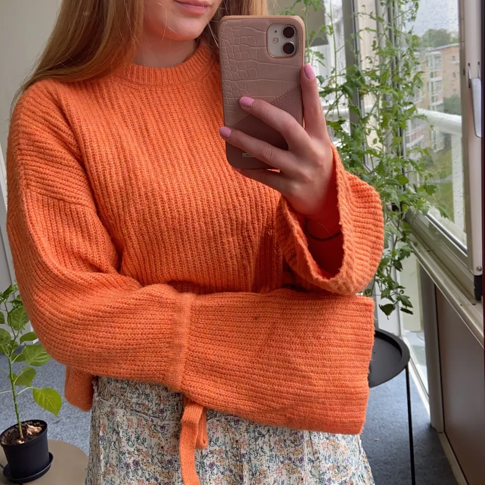 Jättehärlig stickad orange tröja från Nakd med fina detaljer såsom rosetter vid ärmarna och breda ärmar. Hur go som helst. Sparsamt använd men har en liten ögla som syns på bild 3 🧡. Stickat.