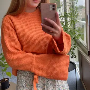 Jättehärlig stickad orange tröja från Nakd med fina detaljer såsom rosetter vid ärmarna och breda ärmar. Hur go som helst. Sparsamt använd men har en liten ögla som syns på bild 3 🧡