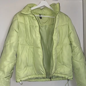 Neon grön jacka i storlek XS - Neon grön jacka från H&M i storlek XS, men passar även större storlekar. Den har justerbara band längst ner så man kan dra åt eller upp som man själv vill. Bild 3 visar färgen bäst. Fint skick, inga fläckar osv. Väldigt varm jacka, fungerar perfekt nu till hösten och vintern.