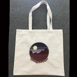 Tygkasse/tygpåse 40x38cm - Säljer min tygkasse som jag målar på fri hand. Självaste påsen är från panduro och information om den finns på andra bilden. Motivet är inspirerat från Harry Styles låt ”Canyon moon”. Det finns även en liten fläck med färg på den men ska försöka måla över den💕 Säljer för 50 + frakt, om man vill ha spår bar frakt blir det 50 + 66kr frakt💕 Om fler är intresserade blir det budgivning!