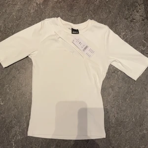 Vit topp med cutout från gina tricot - Helt ny topp från Gina tricot med prislapp kvar, förstor för mig då jag har XXS. Ärmarna är lite längre än vanliga t-shirts. Modellen heter ”Bella cut out top”, köptes för 259kr. Lappen har ramlat av nu. Pris kan diskuteras