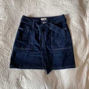 Jeanskjol Topshop - Jättesöt jeanskjol från topshop i strlk 38! Säljes då den inte längre passar mig. Då den går att knyta åt funkar den lika bra på 36 som 38 🥰 Använd men i bra skick!