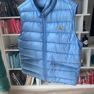Moncler väst  - Säljer nu denna moncler väst i färgen baby blå, väldigt Sällsynt färg! Fint skick. Kommer med tillhörande säck och påse med extra knappar! Storlek 3 vilket är M/L