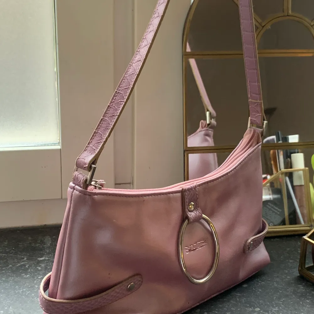 En liten rosa handväska från Bozzini. Den har lite slitage här o var men annars i fint skick! En perfekt handväska🌸. Väskor.