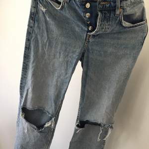 Jeans croppade med hål vid knäna i storlek 34. Totala längden är 95 cm och dom slutar en bit ovanför ankeln på mig som är 171 cm lång. Hämtas i Örebro eller skickas mot fraktkostnaden!
