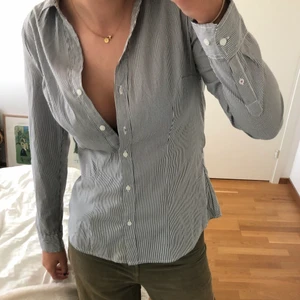 Figursydd skjorta - En SUPERfin randig figursydd skjorta! Sitter väldigt fint på och kan både kläs upp och ner. Jag skulle säga att den sitter som en S/M. Säljer då den inte riktigt är min stil längre😌 knappt använd