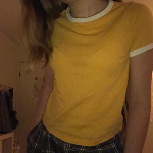Gul T-shirt  - Säljer denna snygga gula T-shirt i fint skick med vita ärmar och krage. Ser snygg ut på människor av alla kön😊 Lappen är tyvärr borttagen men den passar mig som är XS-S, och jag tror även att den hade passat någon som är M-L💕