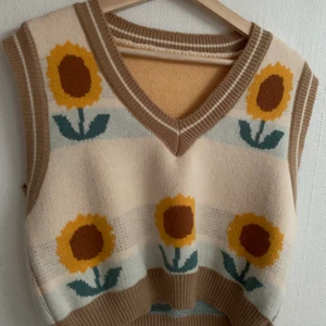 Vest - Super fin vest med solrosor på, stickad, beige med gula solrosor och ljusblå detaljer, storlek s-m, aldrig använd, perfekt för sommaren, köparen står för frakten