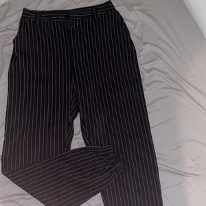 Randiga byxor stlk 40 - Snygga ”all-around” byxor. Svarta med vita ränder. Märke: missguided. Passform: pösiga längst benen, snyggt om rumpan. Köparen står för frakten.