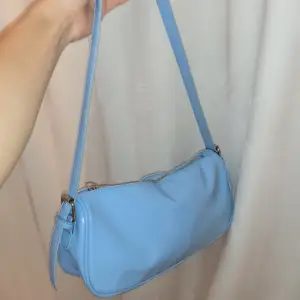 Underbar lack väska från Nelly i en blå färg. Skicket är bra men lite ”repor” längs kanten på ena sidan av väskan. 