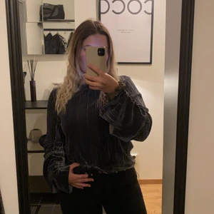 Tröja stl 38 - En grå tröja, men lite volang vid slutet av ärmarna. Från Nelly, Stl 38.