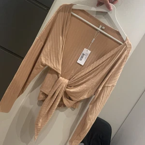 Tröja som man knyter i midjan  - Oanvänd tröja i beige, storlek S 