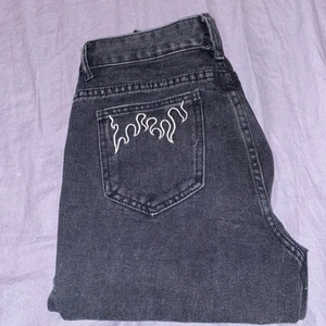 svarta jeans - Säljer ett par svart Jeans med lågor på bakfickan då dem inte kommer till använding och börjar bli för små. Ganska raka i formen. Strl Xs, passar även en xxs