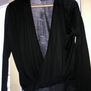 Omlott tröja - Svart mjuk omlottröja. Funkar både baklänges och framlänges. Använd 1 gång.