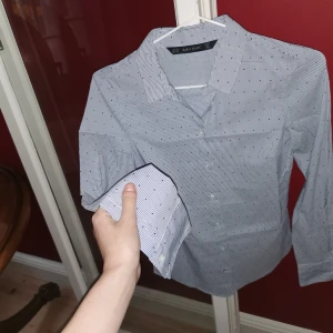 blå Zara skjorta xs/32/34 - Zara basic skjorta väldigt sparsamt använd, som nyskick! prickar och ränder i blått. obs: storlek xs men ganska liten i storleken också. passar petite/tajt fit