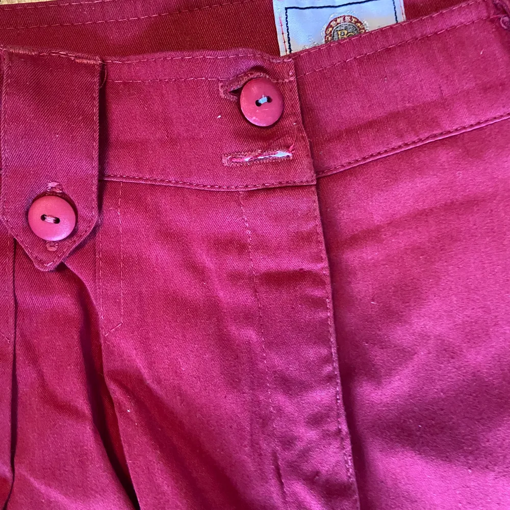 Säljer dessa röda/rosa byxor med hög midja. Lite noppiga och saknar en knapp (se sista bilden) men går lätt att sy dit. Slutar ovanför anklarna på mig (166). Köparen står för frakten. . Jeans & Byxor.