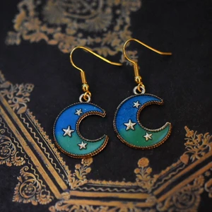 Örhängen med månberlock - Handgjorda örhängen med guldpläterad berlock och nickelfria krokar 🌙 På min profil finns fler örhängen med berlocker i flera andra storlekar, färger och former! 🪐 Köp 1 par för 40kr, 2 par för 70kr, 3 par för 100kr! Örhängena levereras i en fin liten presentpåse. Frakt på 13kr tillkommer 💫