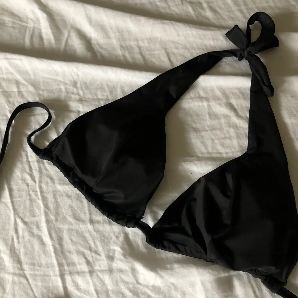 En svart triangel bikini topp, iprincip oanvänd . Accessoarer.