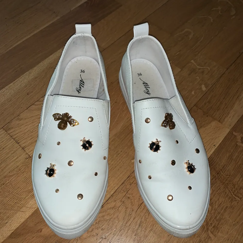 Vita slip on skor med fina våriga dekorationer 😋. Skor.