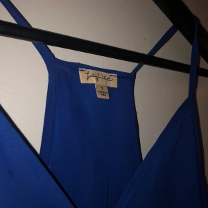 Ett Blått blus linne  - Ett blått blus linne. Made in USA med SIZE S. Lite längre baktill med fin V ringning.