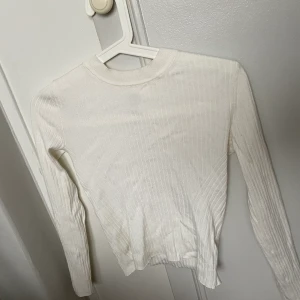Vit ribbad tröja - Långärmad vit ribbad tröja. Använd få gånger och är i nyskick. Ganska Stretchig så passar även S