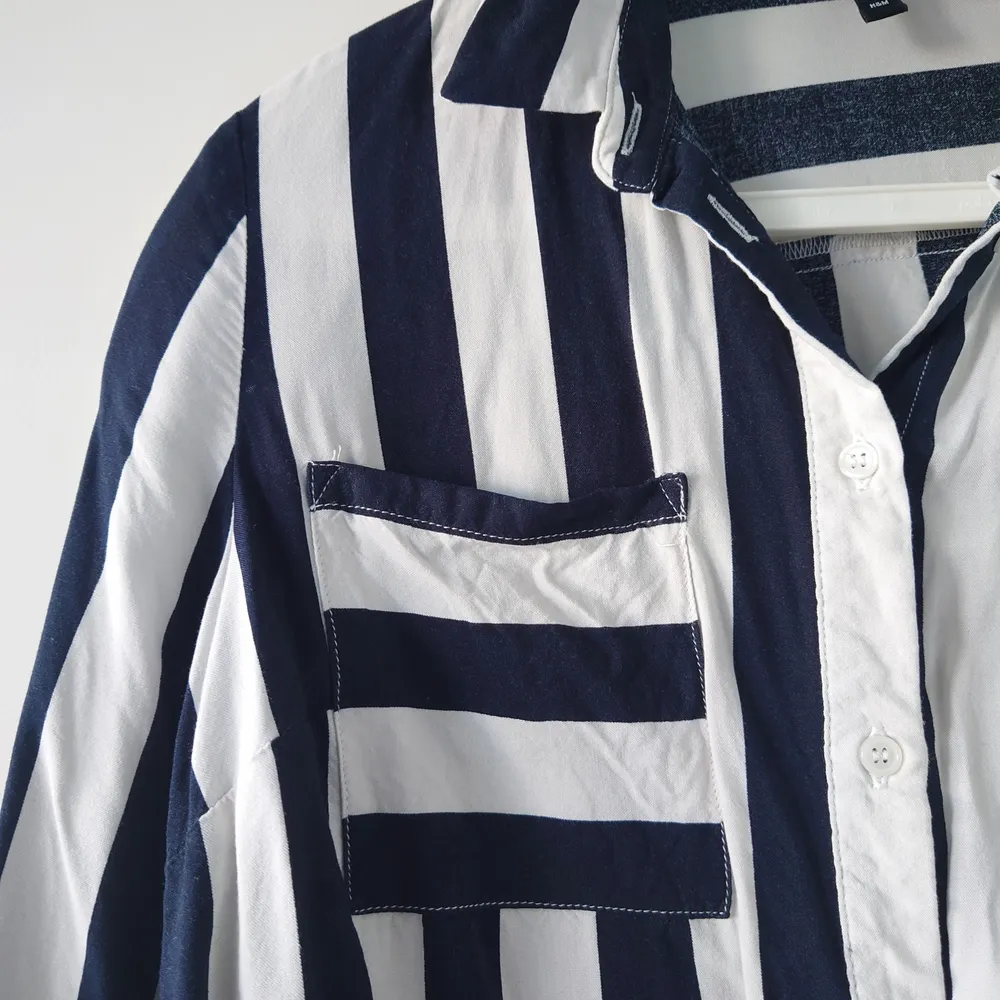 Skjorta från H&M i randigt vit och mörkblå, strl 36. Använd en gång, i nyskick! Köparen står för frakt, går att skicka billigare men då ej spårbart. . Skjortor.