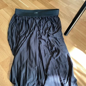 Kjol - Svart plisserad kjol, går till strax nedanför knäna. Prislapp borta men oanvänd.