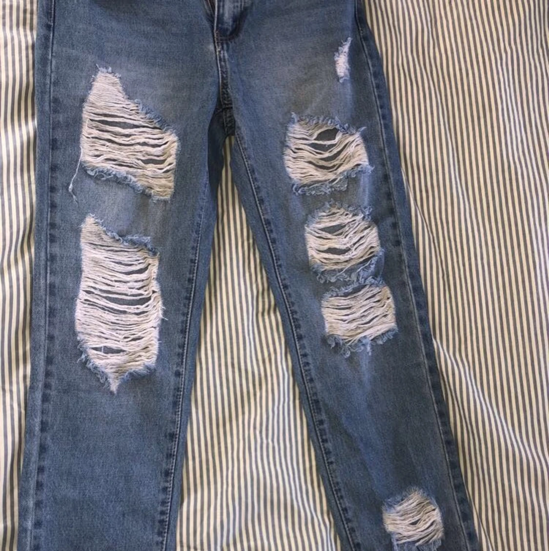 Högmidjade slitna jeans