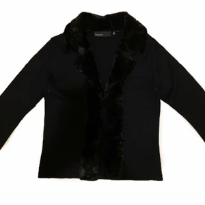 Pälskofta - Svart kofta med snygga pälsdetaljer, i äkta y2k/90-tals stuk. Kommer ifrån Kappahl och är i nyskick, storlek 36/38.