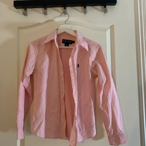 Rosa Ralph Lauren Skjorta  - Säljer denna rosa Ralph Lauren skjorta i super fint skick då jag inte använder den, har använt den tre/fyra ggr. Är i strl 38 men passar även mig med strl 36. Skriv för fler bilder/bilder med plagget på. Köpare står för frakt och pris kan diskuteras vid snabb affär❣️