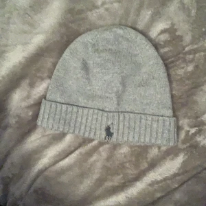 Grå Ralph lauren mössa - En superfin grå Ralph lauren mössa. Väldigt fint skick, köptes för 500kr. Säljer för 250kr