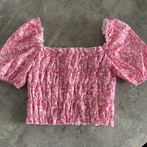NY rosa topp  - Jättefin rosa topp med vita blommor på från Shein, aldrig använd! Man kan ha den både off-shoulder och uppe på axlarna. Strl S/M. Frakt tillkommer om den ska skickas🥰