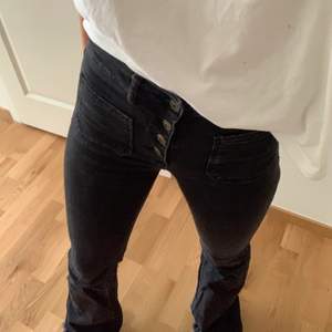 Svarta zara jeans med synliga knappar och fickor på framsidan. 