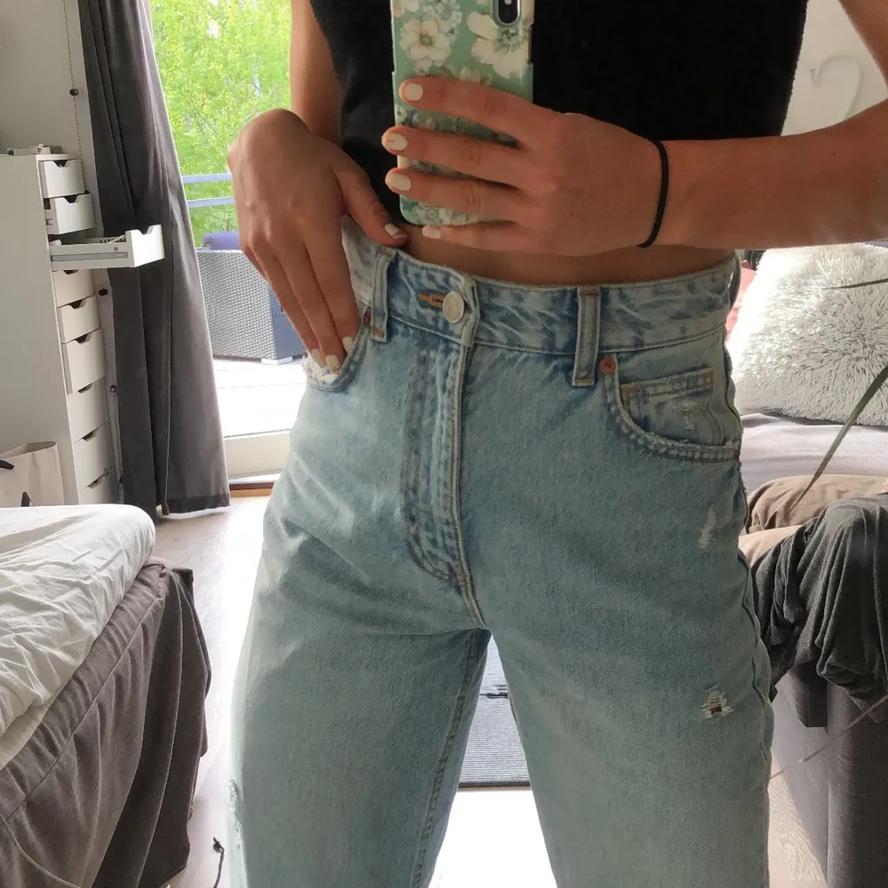 Säljer dessa super nygga jeans från Zara i modellen 90’s! Storlek 34 skulle säga att de motsvarar en S eller Xs! Dom perfekta jeansen nu i sommar med hål på knäna och en ljus blå färg så man ser extra brun ut☀️ Bara använda en gång men säljer pga vill köpa en större storlek!🦋💅🏽. Jeans & Byxor.