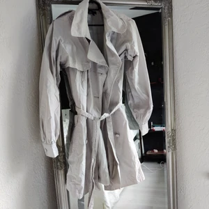 Kappa - En kappa i grå/vit färg. Storlek 40 men passar även S/M. Den har avtagbara ärmar som man kan knäppa på/av. Köpt secondhand av min mamma men den har aldrig kommit till användning 🤍