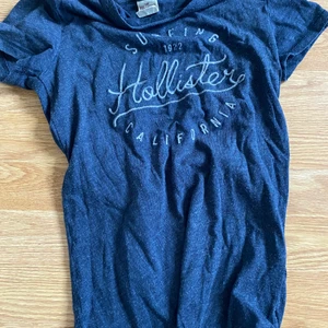 Blå Hollister tröja med tryck - En blå t-shirt från hollister med ett vitt tryck, har inte använt mycket 