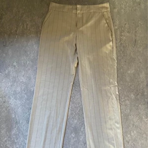 Randiga kostymbyxor  - Beigea, randiga kostymbyxor från Mango i storlek 38. Perfekta till våren/sommaren! Endast använda ett fåtal gånger. Köparen står för ev. frakt!