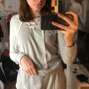 Grå sweater med snörning - En grå sweater med snörning som sitter bra på kroppen! I storlek S men funkar till både M och XS beroende på hur du vill den ska sitta på
