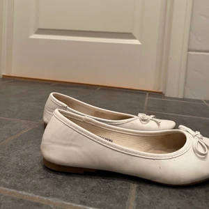 Vita ballerinaskor i skin - Vita ballerinaskor i vitt skin med en rosett. Dom är andvända men ändå fina. Storlek 37. 250kr + frakt💞