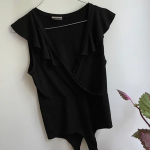 Volangbody - En snygg svart body med volangkrage. Stretchigt material, knäpps nedtill. Möts upp i Växjö ev. Gbg eller fraktar 🌸💫