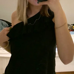 One shoulder topp strl:xs - Svart one shoulder topp med en liten volang. Strl:XS. Från H&M.                                           Fraktkostnaden står köparen för!😊