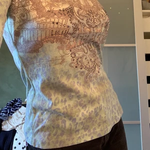 Mönstrig T-shirt  - Blå/lila/grå tröja med silversten-detaljer.