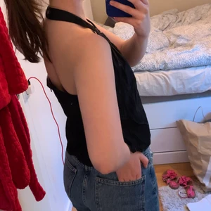 Svart topp med öppen rygg - Detaljer syns på bild 3 (den är ej smutsig, det är min spegel). Tröja från 90-talet. Svart. Bra skick, inget trasigt inga fläckar. Man knäpper kragen med knappar