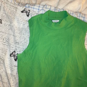 kortärmad polo topp - Grön topp från Monki med en kort polokrage i storlek L. Helt oanvänd & säljs för 70kr