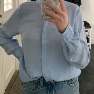 Skjorta från hm str 38 - Ljusblå skjorta från hm, första bilden visar färgen bäst💙 väldigt tunt och skönt matrial, använd fåtal gånger! str 38💙 40kr, frakt ingår inte i priset!