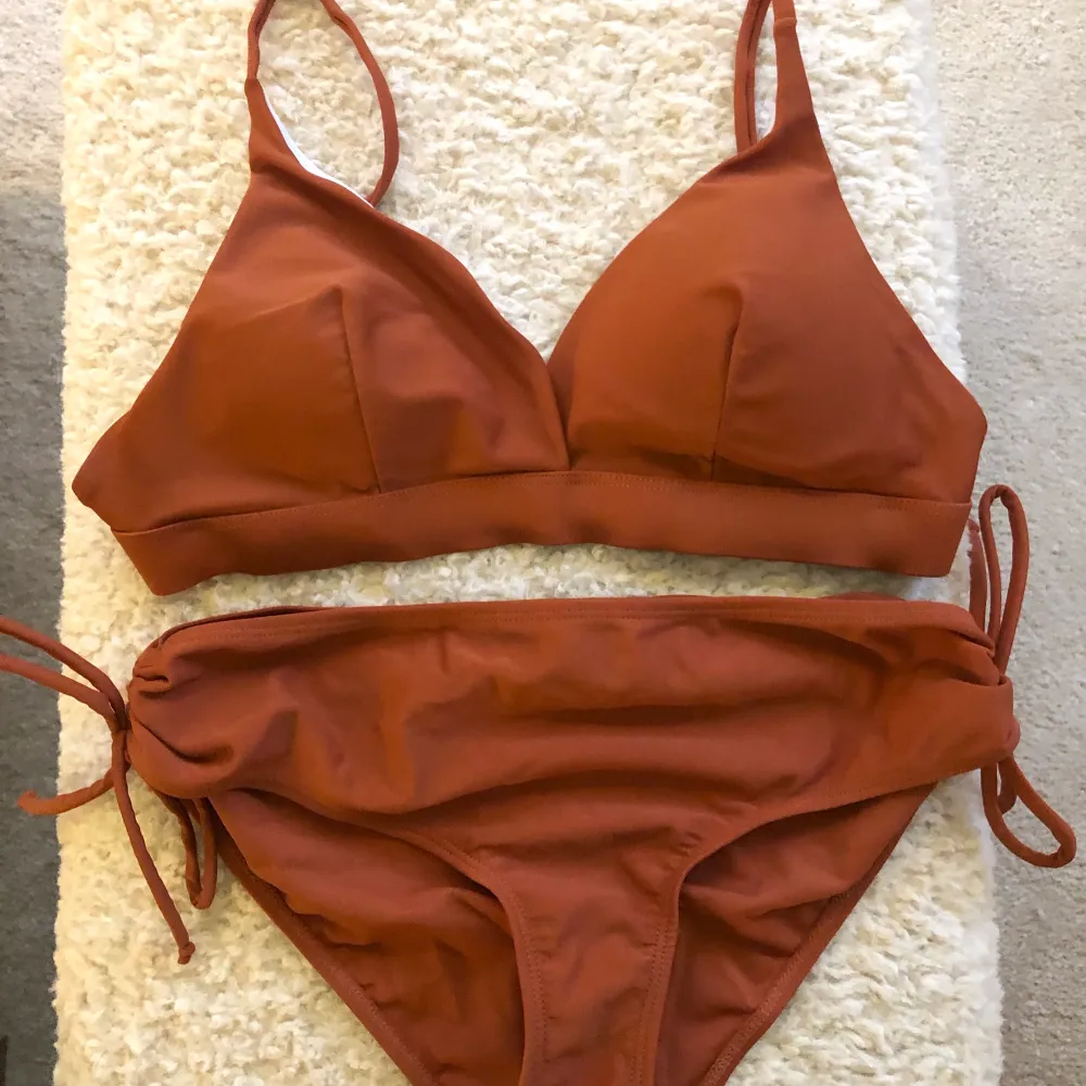 Rödbrun bikini i storlek S. Har knytfunktion på underdelen som går att justera, och även banden på bikinitoppen är justerbara. Aldrig använd :). Övrigt.