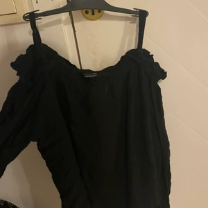 Tröja utan axlar - En svart tröja där axlarna syns, med axelband som går att justera. Från gina tricot i storlek 36 men passar även 34.