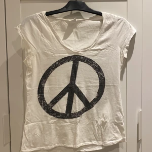 Vit Gina Vringad tröja med peacetecken - Liten L, mer som M. Hämtas eller möts upp i Limhamn/Malmö. Skickas inte