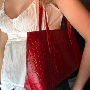 En riktigt snygg röd väska, vintige. Den är rymlig. Axel väska, avlång väska i mycket bra skick! Säljer då den inte längre iommer till andvänding. Perfekt till fina sommar outfits! 