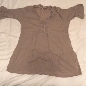    - Brun blus med halv långa ärmar 